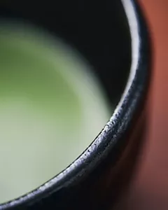 A close-up image of matcha green tea; its refreshing green colour is shown in a blurry manner.
