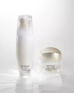 White moisturiser bottle and jar placed against a bright white background.